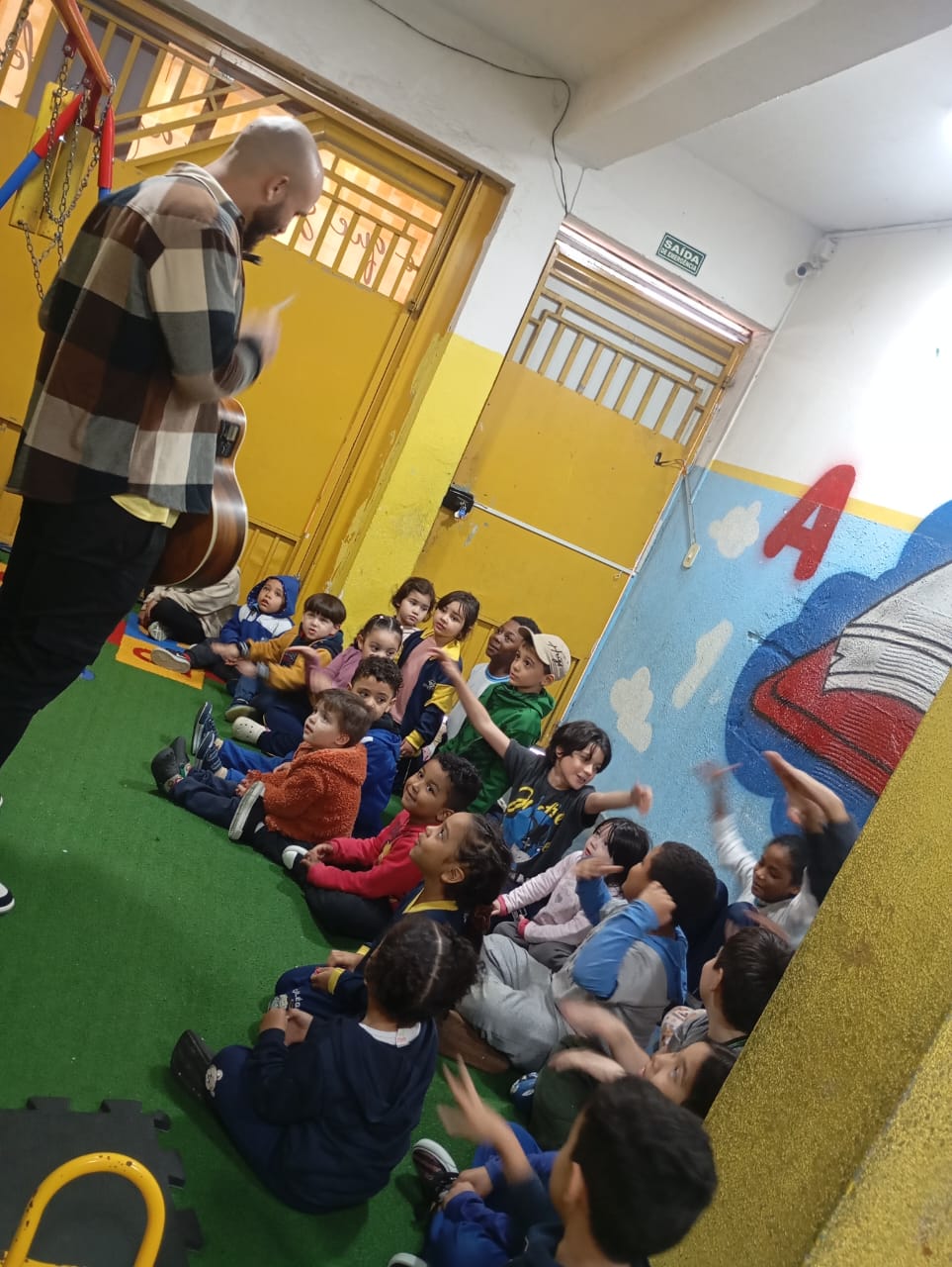 Grupo de crianças participando de uma atividade musical em uma escola